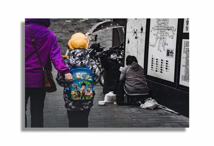 Adult and child walking through a narrow lane