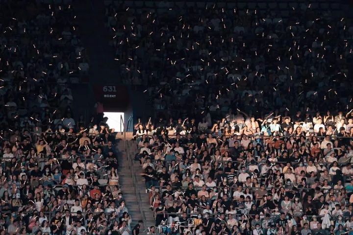 A beam of light across a crowded stadium stand
