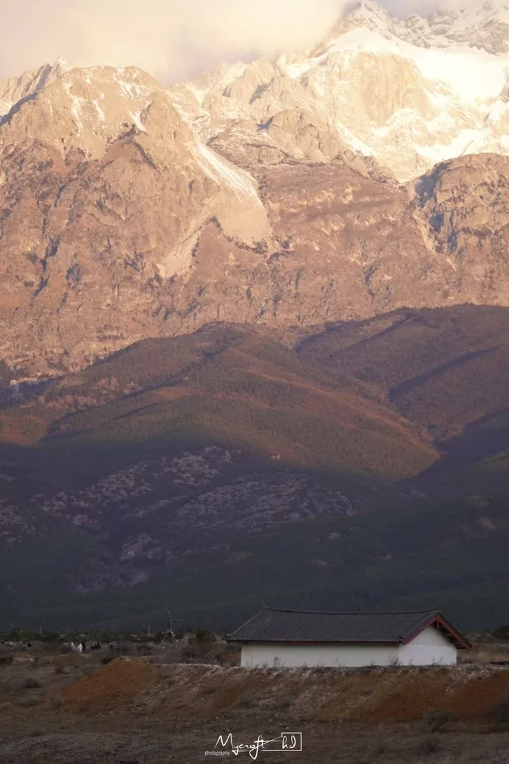 Snow-covered peaks above a small building